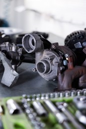Photo of Different auto parts and tools on grey table indoors, closeup