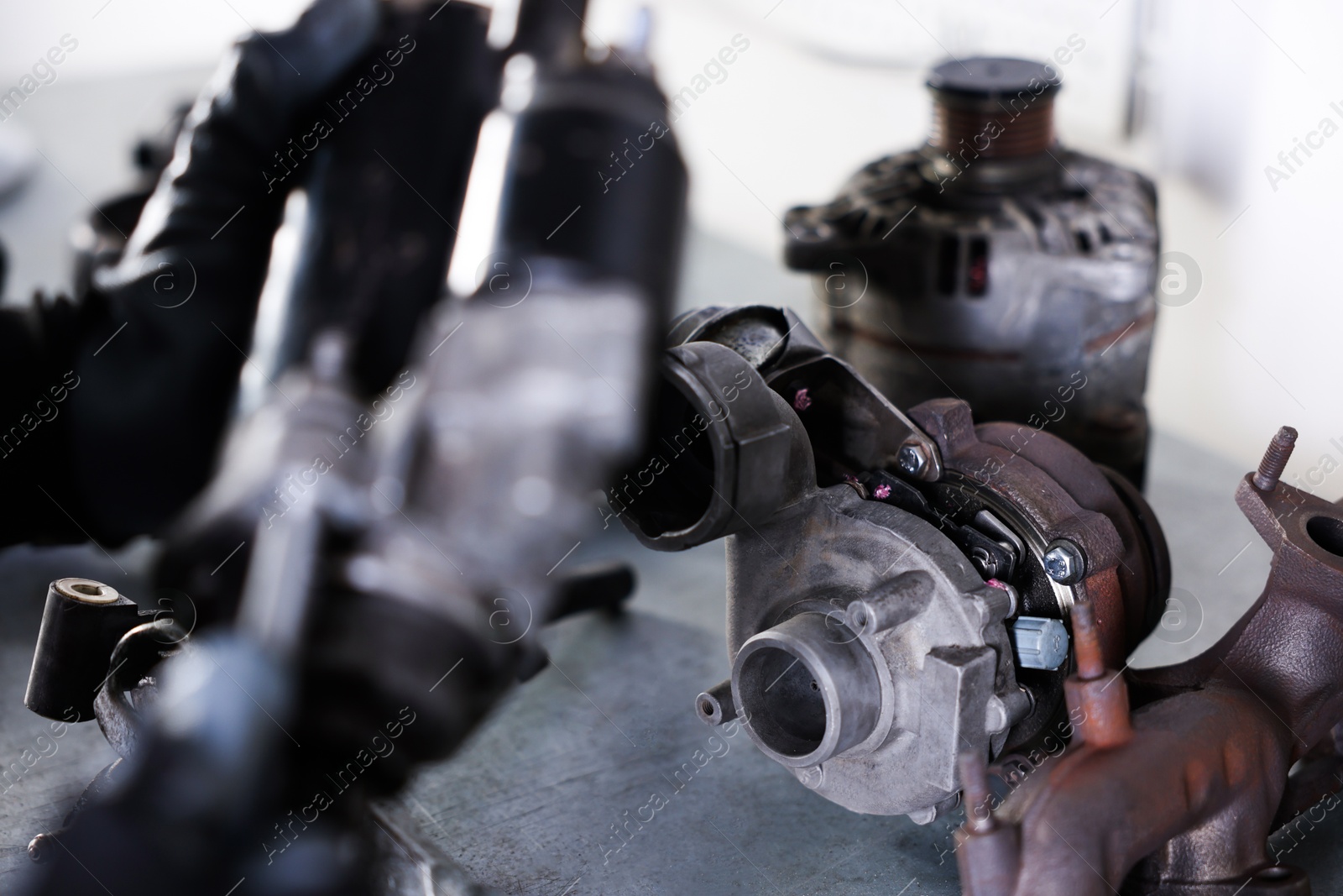 Auto parts. Professional mechanic with starter motor indoors, focus on turbocharger Photo of Auto parts. Professional mechanic with starter motor indoors, focus on turbocharger