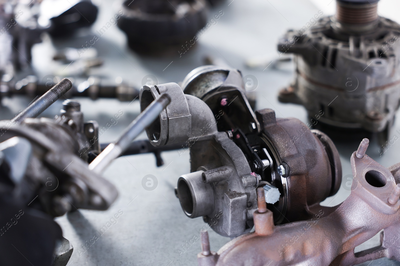 Different auto parts on grey table indoors, closeup Photo of Different auto parts on grey table indoors, closeup