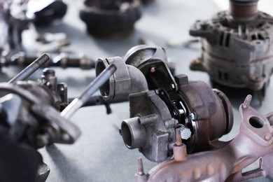 Photo of Different auto parts on grey table indoors, closeup