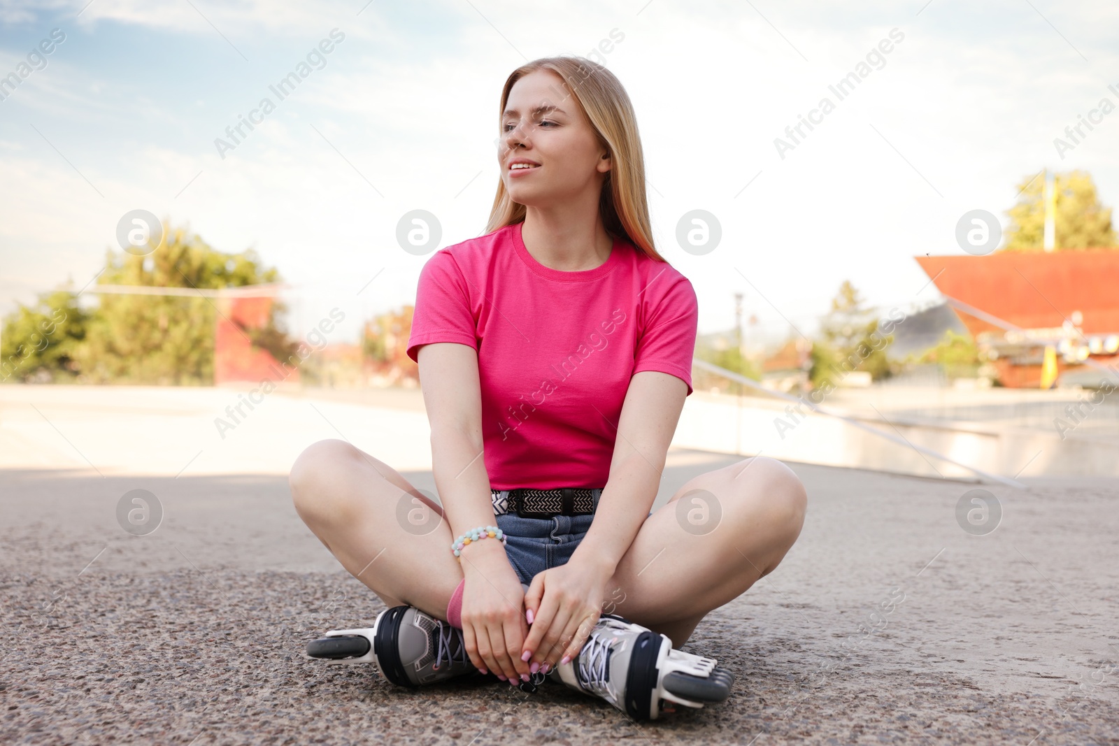 Happy woman with roller skates on street Photo of Happy woman with roller skates on street