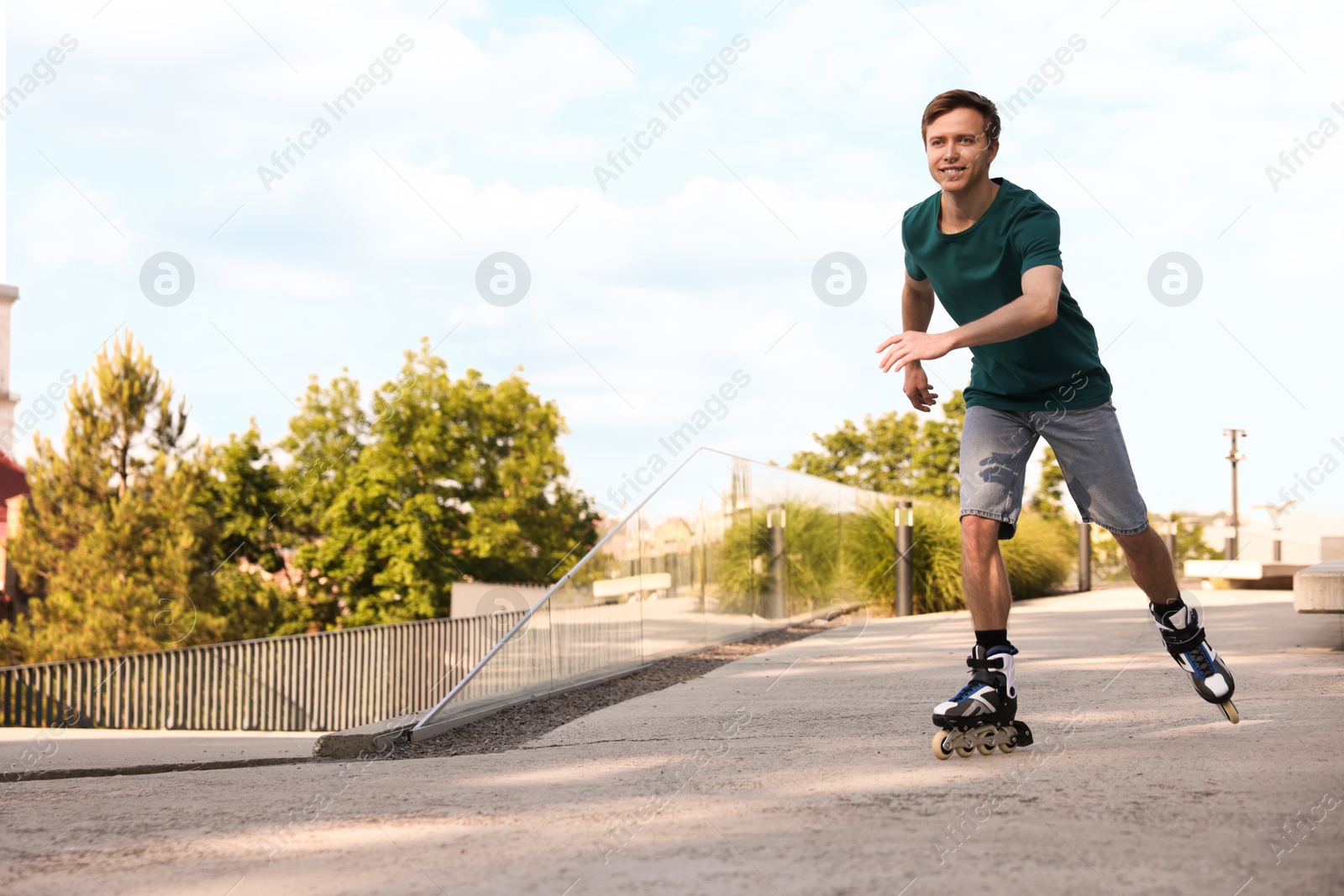 Happy man roller skating on city street. Space for text Photo of Happy man roller skating on city street. Space for text