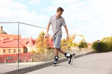 Photo of Happy man roller skating on city street