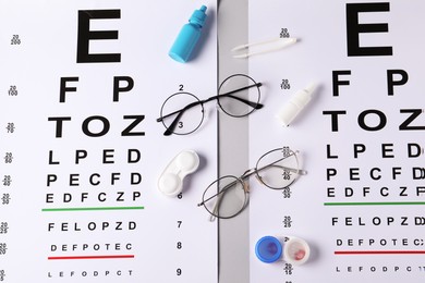 Photo of Vision test charts, glasses, tweezers, lenses and bottles of medical drops on light grey background, flat lay