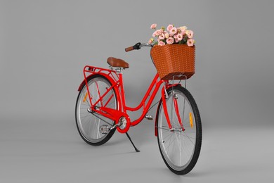 Photo of Bicycle with basket of beautiful flowers on grey background