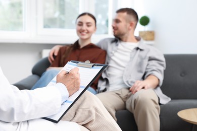 Photo of In vitro fertilization (IVF). Couple having consultation with doctor in reproductive clinic, selective focus
