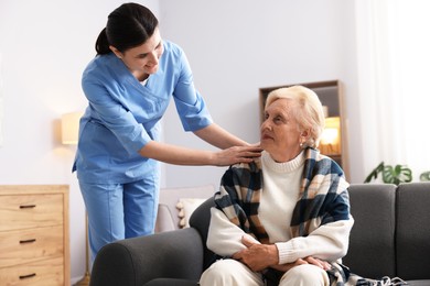 Photo of Nurse assisting senior woman indoors. Home health care service