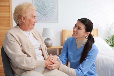 Photo of Nurse assisting senior woman indoors. Home health care service