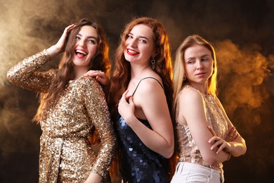 Photo of Beautiful women with different hair colors on dark background with smoke