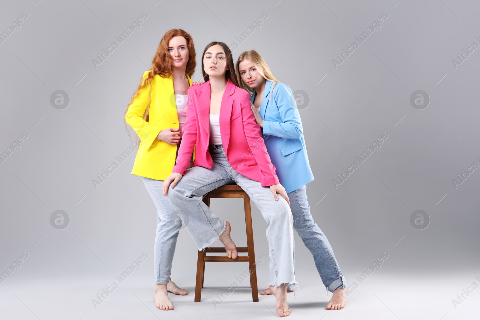 Beautiful women with different hair colors on light grey background Photo of Beautiful women with different hair colors on light grey background