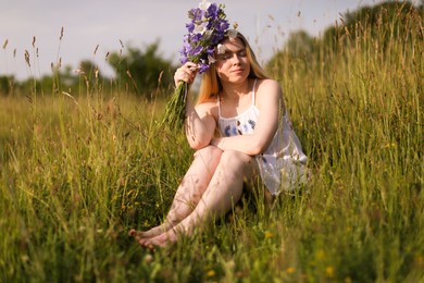Photo of Beautiful woman with bouquet of wildflowers enjoying sunny day in meadow