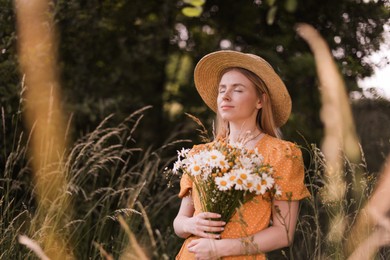 Photo of Beautiful woman with bouquet of wildflowers in meadow