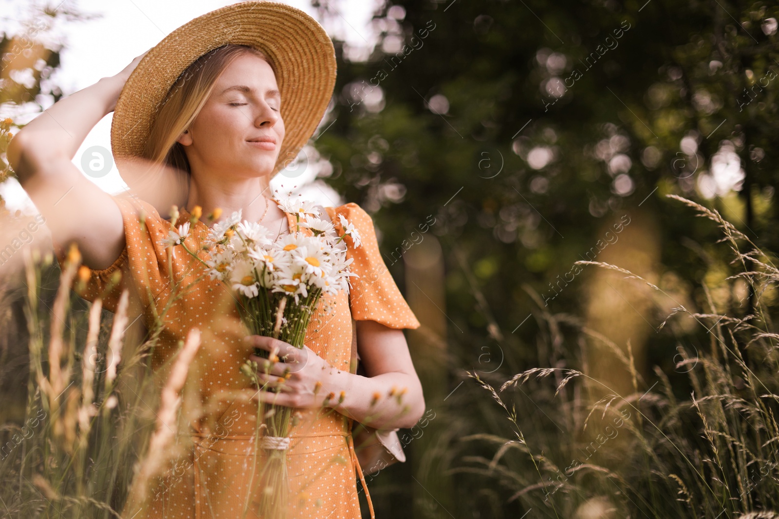 Beautiful woman with bouquet of wildflowers in meadow Photo of Beautiful woman with bouquet of wildflowers in meadow