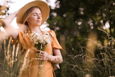 Photo of Beautiful woman with bouquet of wildflowers in meadow