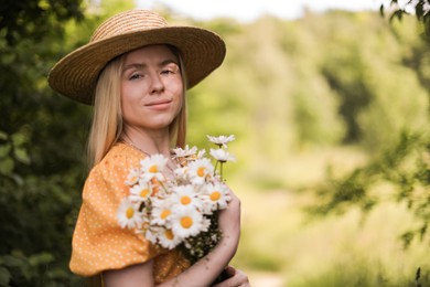 Photo of Beautiful woman with bouquet of wildflowers in forest
