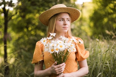 Photo of Beautiful woman with bouquet of wildflowers in forest