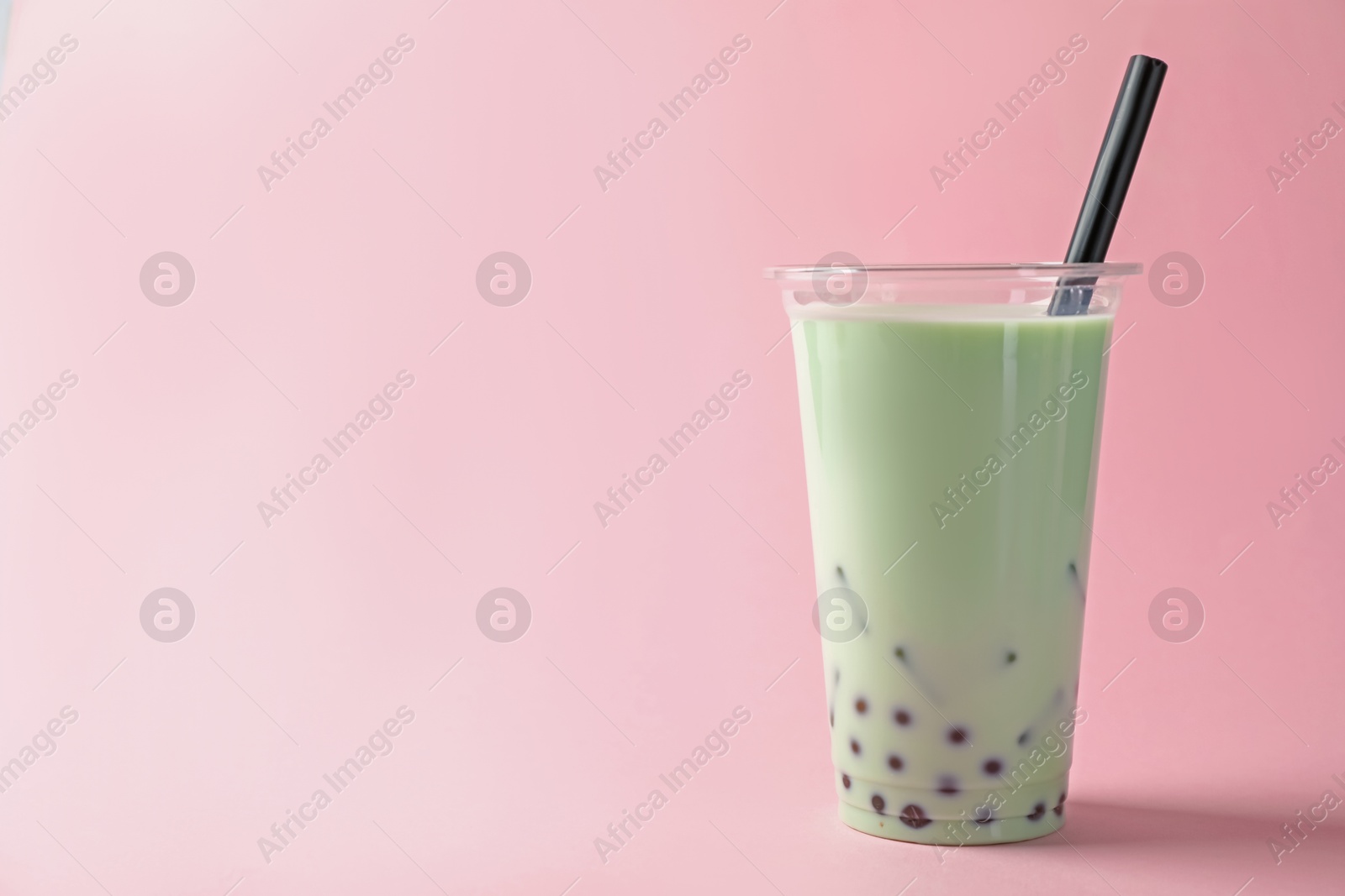 Tasty milk bubble tea in plastic cup on pink background. Space for text Photo of Tasty milk bubble tea in plastic cup on pink background. Space for text