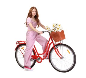 Photo of Beautiful teenage girl posing on bicycle with basket of flowers against white background