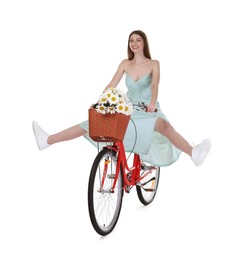 Photo of Smiling woman riding bicycle with basket of flowers against white background