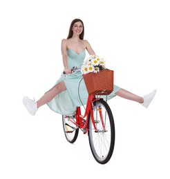 Photo of Smiling woman riding bicycle with basket of flowers against white background