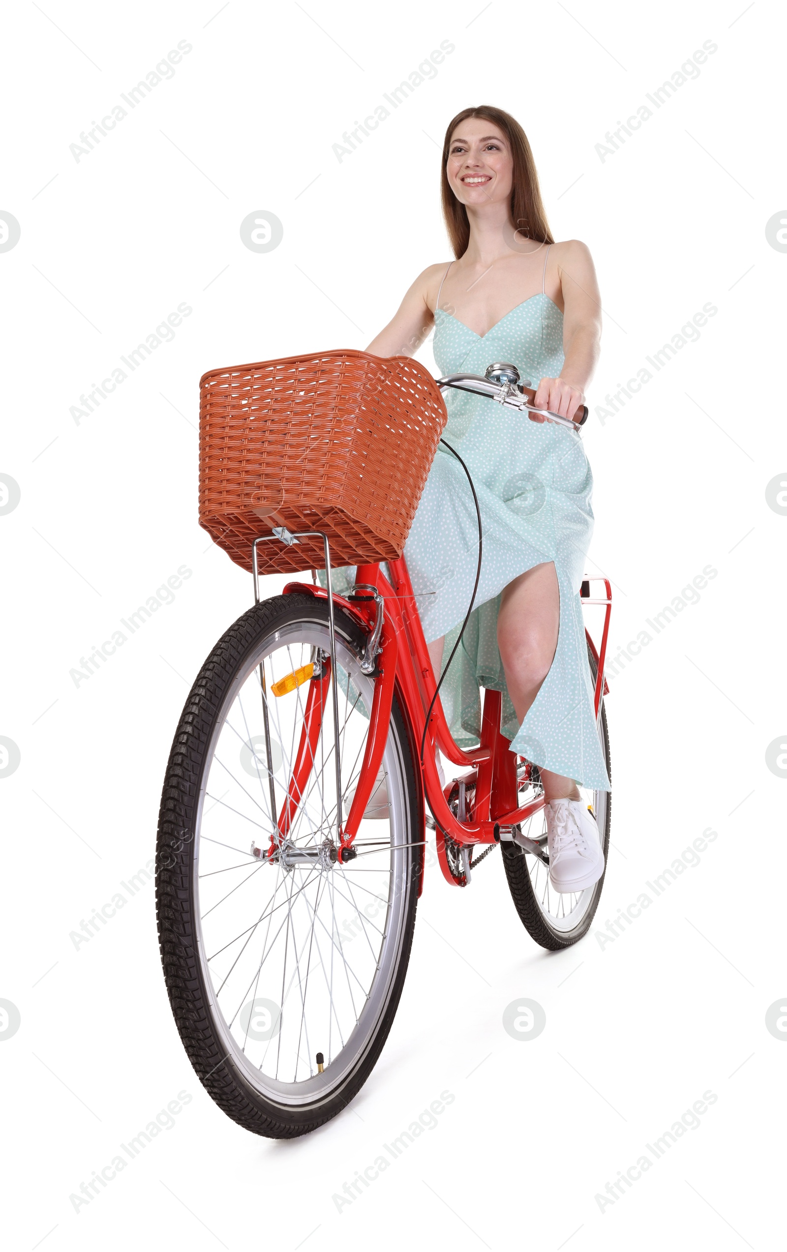 Photo of Smiling woman riding bicycle with basket on white background, low angle view