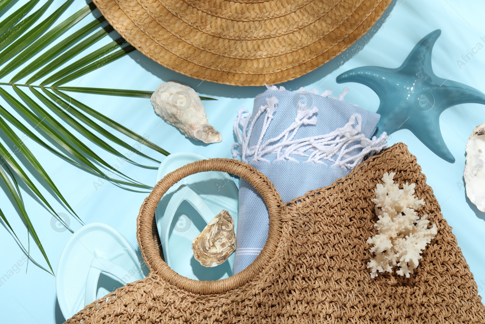 Flat lay composition with different beach accessories and palm leaf on light blue background Photo of Flat lay composition with different beach accessories and palm leaf on light blue background