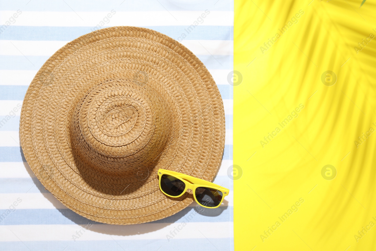 Beach towel, straw hat and sunglasses on yellow background, top view. Space for text Photo of Beach towel, straw hat and sunglasses on yellow background, top view. Space for text