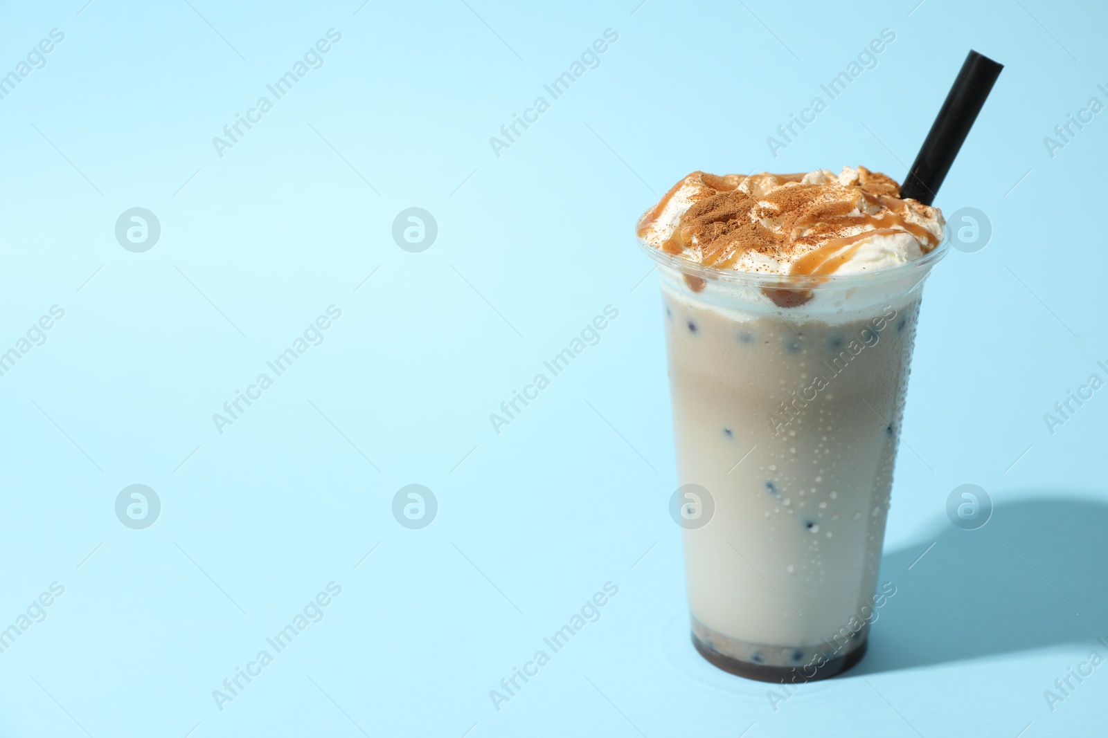Tasty milk bubble tea in plastic cup on light blue background, space for text Photo of Tasty milk bubble tea in plastic cup on light blue background, space for text