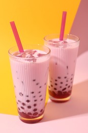 Photo of Tasty milk bubble tea in glasses on color background