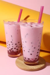 Photo of Tasty milk bubble tea in glasses on color background