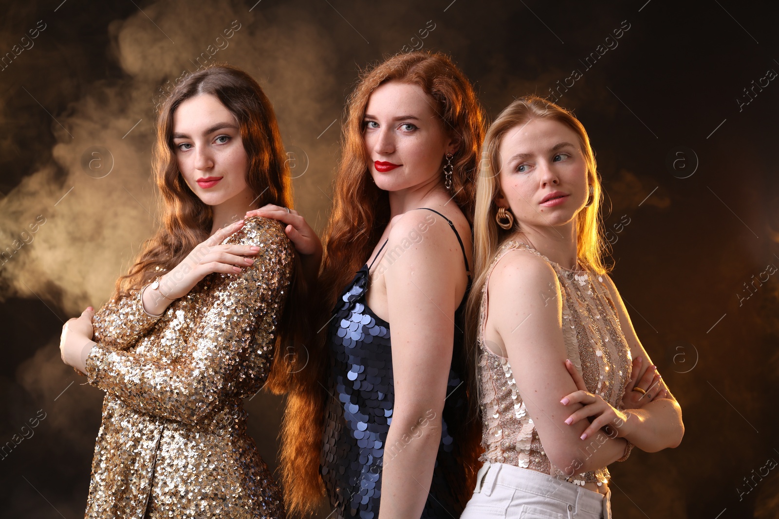 Photo of Beautiful women with different hair colors on dark background with smoke