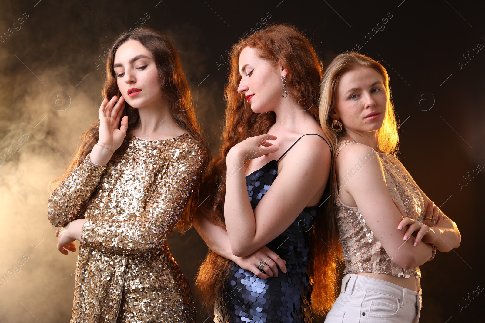 Beautiful women with different hair colors on dark background with smoke Photo of Beautiful women with different hair colors on dark background with smoke
