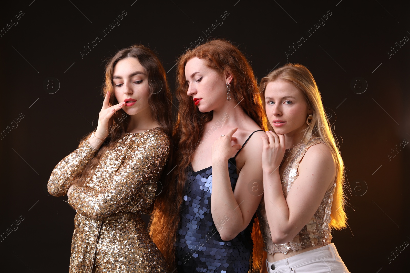 Beautiful women with different hair colors on dark background Photo of Beautiful women with different hair colors on dark background