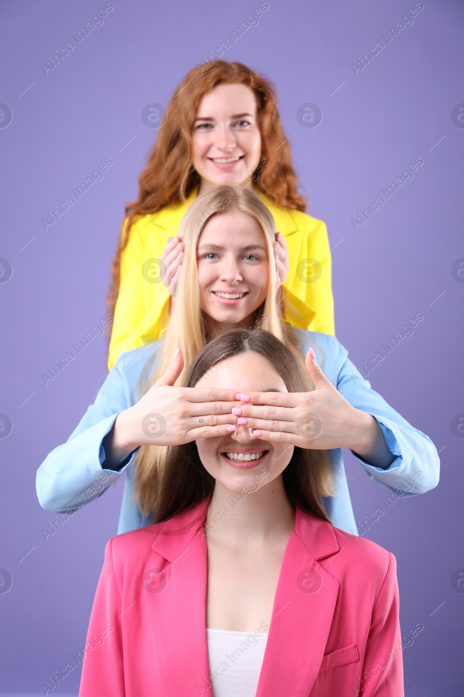 Beautiful women with different hair colors having fun on purple background Photo of Beautiful women with different hair colors having fun on purple background