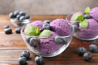 Photo of Tasty sorbet with blueberries and mint served on wooden table, closeup