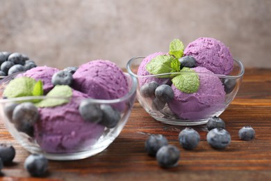 Photo of Tasty sorbet with blueberries and mint served on wooden table, closeup