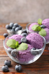 Photo of Tasty sorbet with blueberries and mint served on wooden table, closeup