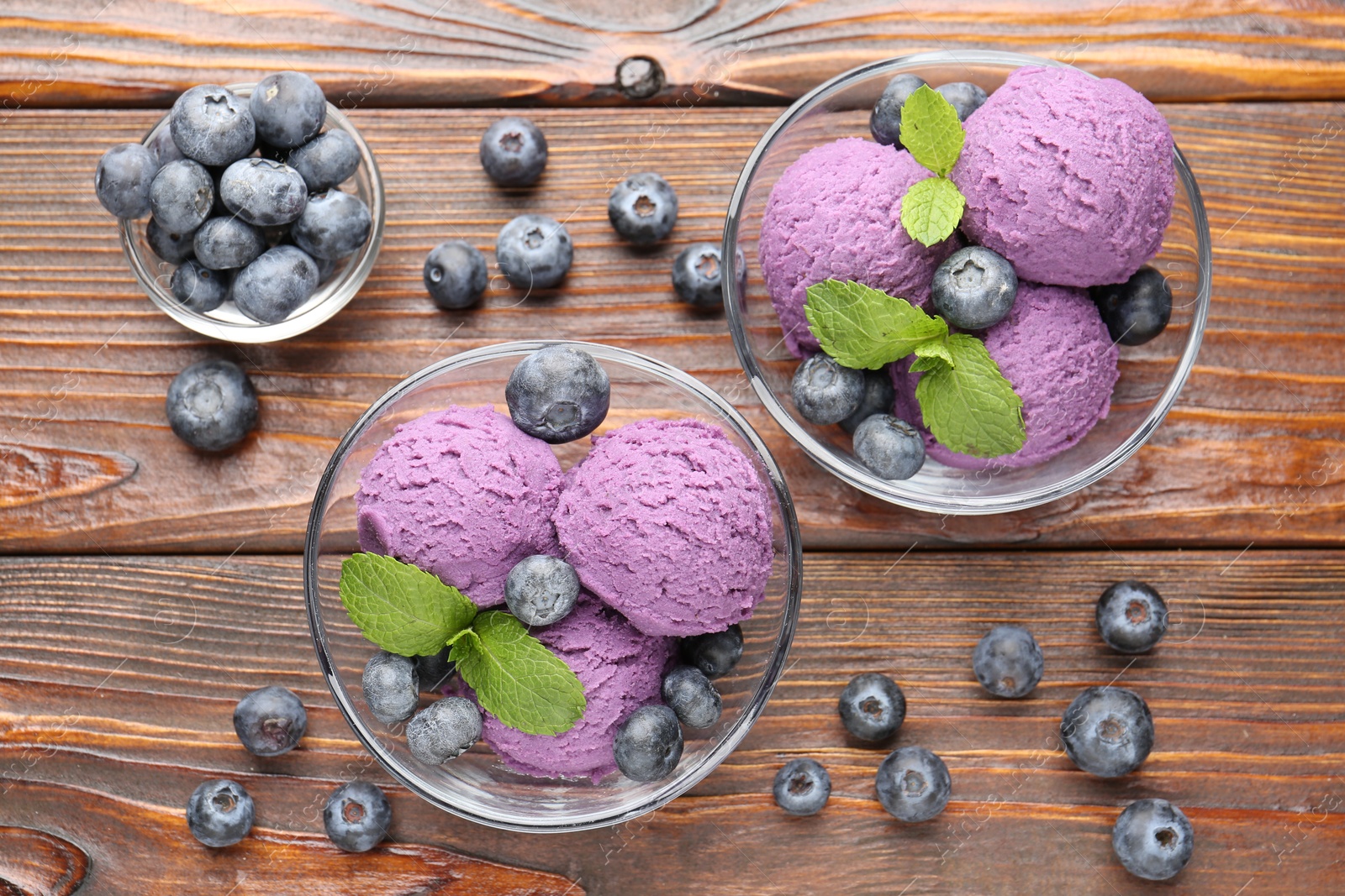 Tasty sorbet with blueberries and mint served on wooden table, flat lay Photo of Tasty sorbet with blueberries and mint served on wooden table, flat lay