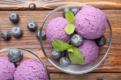Photo of Tasty sorbet with blueberries and mint served on wooden table, flat lay