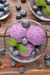 Photo of Tasty sorbet with blueberries and mint served on wooden table, flat lay