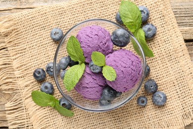 Photo of Tasty sorbet with blueberries and mint served on wooden table, flat lay