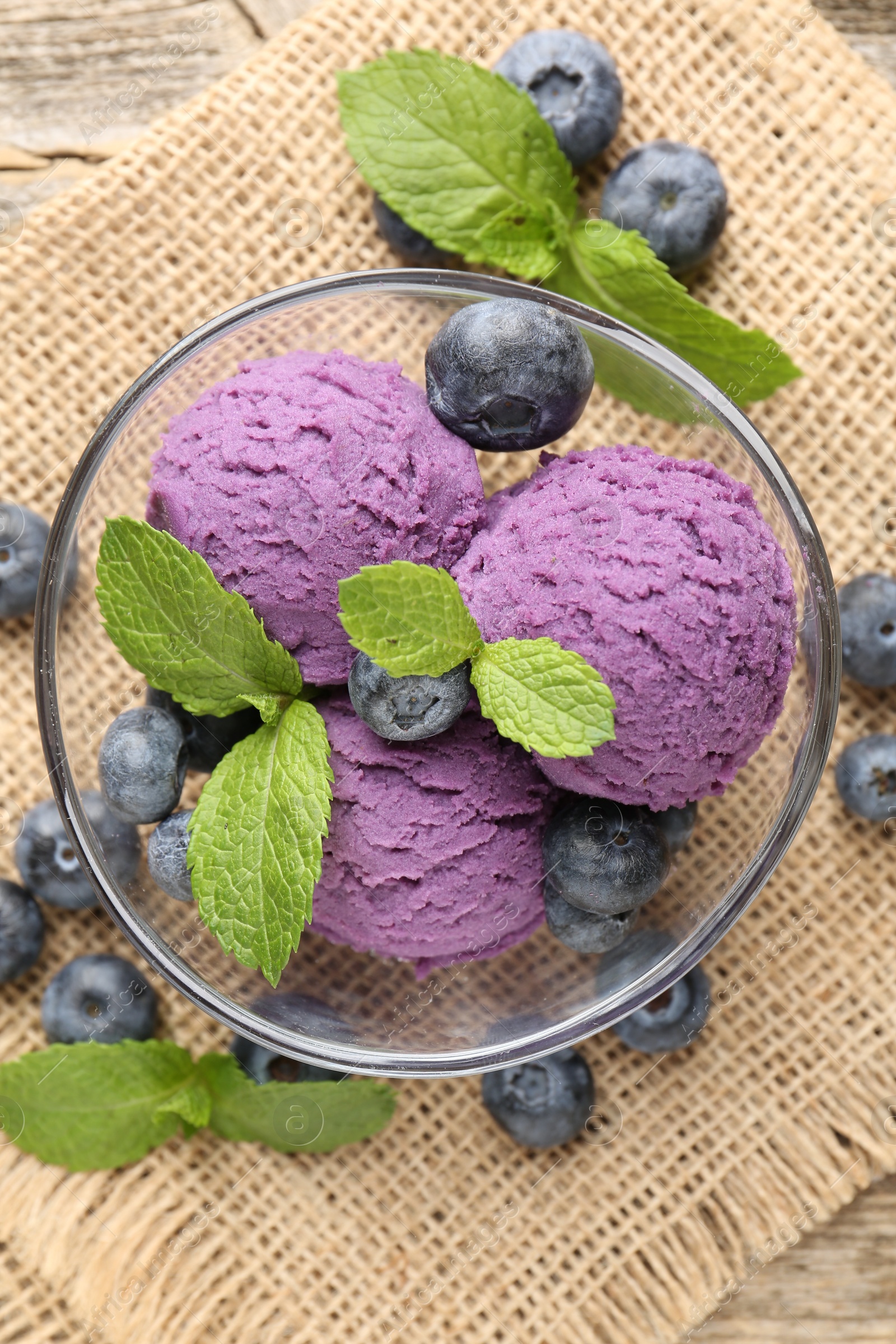 Tasty sorbet with blueberries and mint served on wooden table, flat lay Photo of Tasty sorbet with blueberries and mint served on wooden table, flat lay