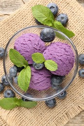 Photo of Tasty sorbet with blueberries and mint served on wooden table, flat lay