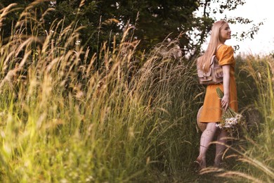 Photo of Beautiful woman with bouquet of wildflowers in meadow