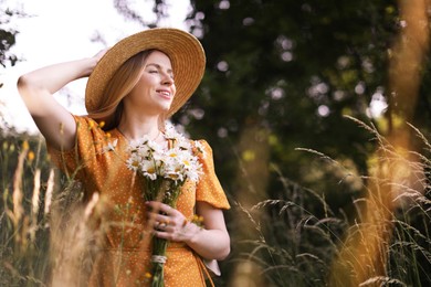 Photo of Beautiful woman with bouquet of wildflowers in meadow