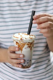 Photo of Woman with tasty milk bubble tea in plastic cup, closeup