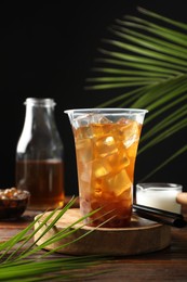 Photo of Tasty iced bubble tea and ingredients on wooden table