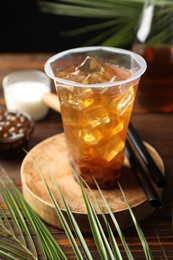 Photo of Tasty iced bubble tea and ingredients on wooden table