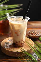 Photo of Tasty iced bubble tea and ingredients on wooden table