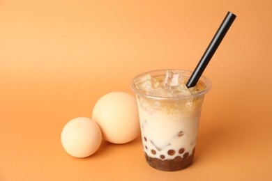 Photo of Tasty iced bubble tea on orange background. Space for text